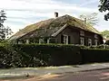 Boerderij op een anker van het woonhuis gedateerd. Het woonhuis, dat een lage verdieping en een rieten schilddak heeft, is dwars op de stal gebouwd. Bovenlicht met gietijzeren levensboom, vensters met luiken en zesruitsramen