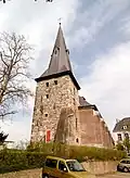 Toren van de vroegere parochiekerk, opgetrokken van ruwe zandsteenblokken, omstreeks 1300