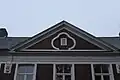 De voorgevel is bekroond met een driehoekig fronton met middenin een oculus.