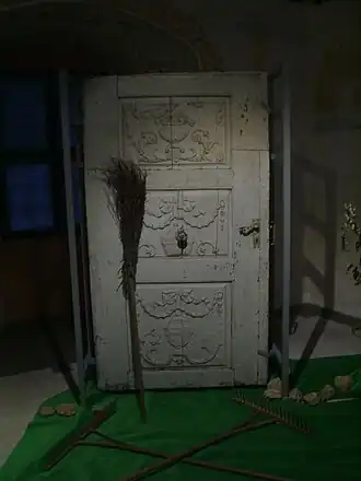 Een bezem met de steel naar beneden bij de deur; bescherming tegen heksen. Museum Forchheim