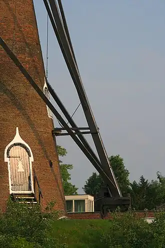 De staart van de molen rust met een wiel tegen de romp