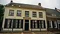 Huis met gepleisterde gevel met rechte lijst