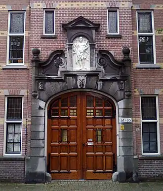 Hoofdingang van het hofje in 2017, met boven de ingang een 17e-eeuws beeld van een vredesengel, afkomstig van het oude hofje