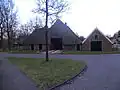 Museumboerderij erve "Hofman", boerderij onder fors rieten schilddak met uilenborden en met onderschoer. De vensters van de voorgevel met luiken behangen. Aan de rechterkant een dwars aangebouwd schuurgedeelte onder rieten schilddak.