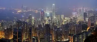 panorama over Hongkong, Kowloon en Victoria Harbour bij nacht vanaf de Victoria Peak