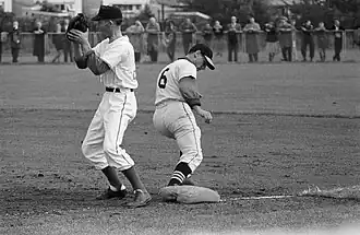 Tromp (links) op eerste honk tijdens de wedstrijd tegen Schoten op 13 augustus 1960