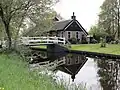Kleine boerderij, behorend tot het grondtastype in de Giethoornse vorm van de hallehuisgroep. Woonhuis onder rieten zadeldak met puntgevel, voorzien van voorschot. Stal onder rieten schilddak met uileborden