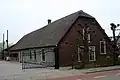 Boerderij "Bouwlust", met wolfgedeelte, dat een 19e-eeuws karakter draagt. Rieten wolfdak; vensters met zesruitsschuiframen. Zomerhuis met ingezwenkte gevel, links van de hoeve een bakstenen wagenschuur onder een zadeldak