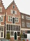 Pand waarvan bij de restauratie in 1962 e.v. boven de verdieping en pui de trapgevel gerestaureerd is; achtergevel gaaf