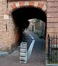 Poortje. Eenvoudige bakstenen poortomlijsting toegang gevend tot het Klooster