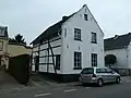 Hoeve van mergel en vakwerk, met open binnenplaats. Aan de straat twee topgevels