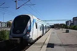 De pendeltåg naar het noorden langs het perron.