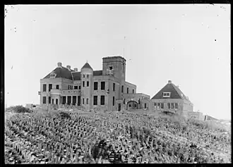 Gezicht op Huis Russenduin. Het buitenverblijf met stalgebouw en chauffeurswoning.