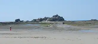 Zicht op het kasteel en het pad ernaartoe bij eb