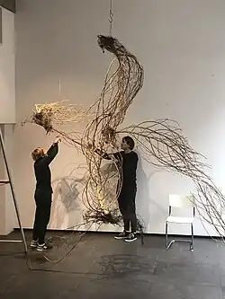 Kunstwerk De Wending in Garage Rotterdam tijdens A new Order, A new Earth tijdens de Expo in 2021 met Golsteijn en Bakker bezig met de inrichting.