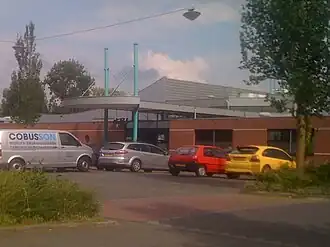 De parking en ingang van het zwembad (2011).