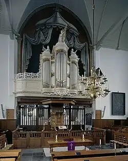 Orgel met preekstoel en doophek eronder en koor erachter (met kleurstelling tot 2019)