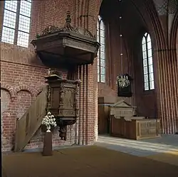 De preekstoel met klankbord met op de achtergrond de herenbank uit 1795