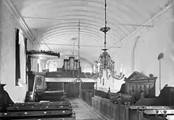 Het kerkinterieur vóór de verbouwing (1941) met de preekstoel, herenbank, galerij met Martin Vermeulen-orgel en kerkbanken