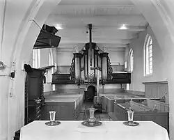 Interieur naar het westen vóór de restauratie (1970). Op de achtergrond bij het orgel de vier bij de restauratie dichtgezette vierkante vensters.
