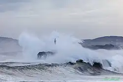 Golven slaan over de vuurtoren.