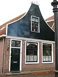 Huis met houten topgevel. Oorspronkelijk kozijnen
