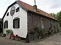 Voormalige Roermolen of Roersemolen. Bakstenen gebouw met wolfdak. Bakstenen schuur. Kreeg na 1954 een andere bestemming