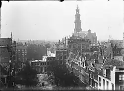 Warmoesgracht 10 t/m 26 (v.r.n.l.). Na de demping en tijdens de doorbraak voor de aanleg van de Raadhuisstraat.Gezien vanaf het dak van Singel 107 naar Herengracht/Keizersgracht/Westermarkt; 1896.