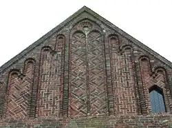 Topgevel zuiderdwarsarm met spitsboognissen, waarvan zes gedekt door klimmende rondbogen