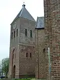 Zijaanzicht toren met links de ingang