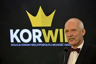 Janusz Korwin-Mikke voor het logo van zijn partij