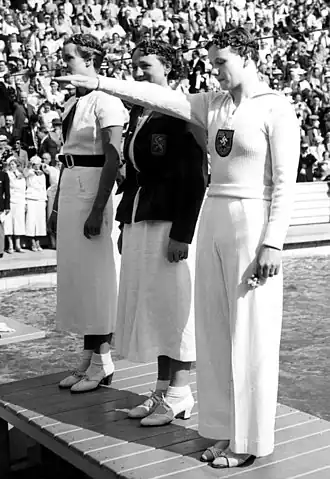 Het podium van de 100 meter vrije slag op de OS 1936: Jeannette Campbell (zilver), Rie Mastenbroek (goud) en Arendt (brons, doet de Hitlergroet)