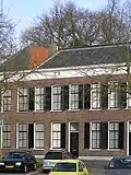 Tweezijdig aangebouwd woonhuis, gebouwd in zeer sobere baksteenarchitectuur met neoclassicistische invloeden in gevelopbouw, verhoudingen en enkele details