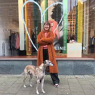 Jolink voor haar winkel in Rotterdam, met haar hazewindhond Zoef.[1]