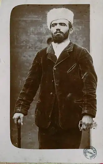 Vacher met een witte bontmuts op, als teken van onschuld.