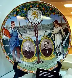 Jubileumbord Société Céramique met portretten De Meeûs en Jaunez