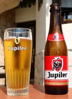 Jupiler-glas met de oude huisstijl en Jupiler-flesje met de nieuwe huisstijl