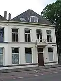 Pand met gepleisterde lijstgevel en schilddak[6]