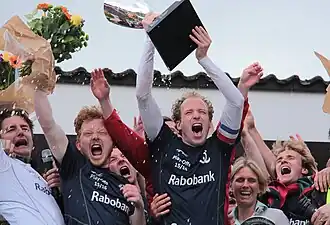 Juigende aanvoerder van Qui Vive met de beker in de handen