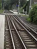 Een ingewikkelde railconstructie in Kassel om de tram dichter bij de perronrand te brengen. Een goederentrein, die niet stopt en die breder is dan een tram, neemt het rechtdoorgaande spoor.