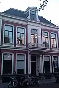 Pand dat onderdeel uitmaakt van een in het derde kwart van de 19e eeuw als een symmetrisch geheel ontworpen straatwand