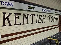 Het tegelwerk met de stationsnaam.