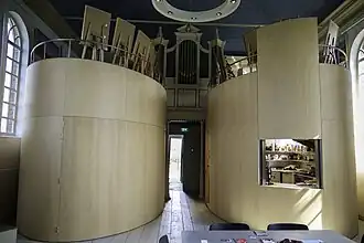 Interieur met twee ovaalvormige inbouwelementen, waar een vergaderzaaltje (links) en een keuken (rechts) zijn gehuisvest