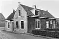 Pand van alleen begane-grond met zadeldak tussen IJsselstenen puntgevels met vlechtingen. Belangrijk door zijn ligging ten Z.W. van de kerk
