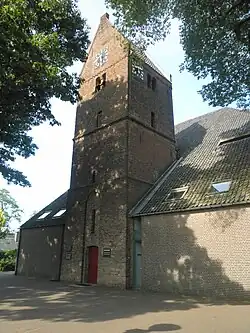 Toren van de Hervormde Kerk : drie geledingen met zadeldak. Segmentboogvormige ingang in hoge spitsboognis