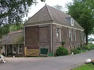 Klarenbeek. Boerderij bestaande uit ten dele houten achtervleugels en dwars daarop, aan de straat, een onderkelderde vleugel onder schilddak