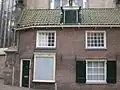 Tegen kooromgang van de kerk aan gebouwd huis met dak