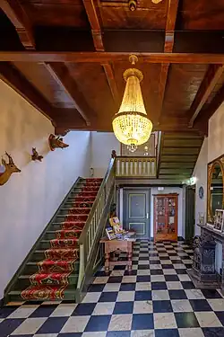 Ingangspartij met links de trap en rechts een 18e-eeuwse schouw uit de stad Groningen