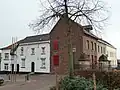 Gepleisterd huis; gevelsteen met ranken en jaartal