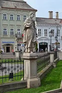 Sint-Margaretha, op een lage pilaster, in de omheining.